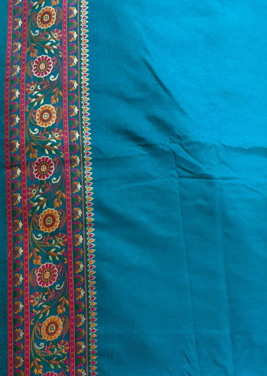 Multicolor floral embroidered border on a peacock teal blue saree