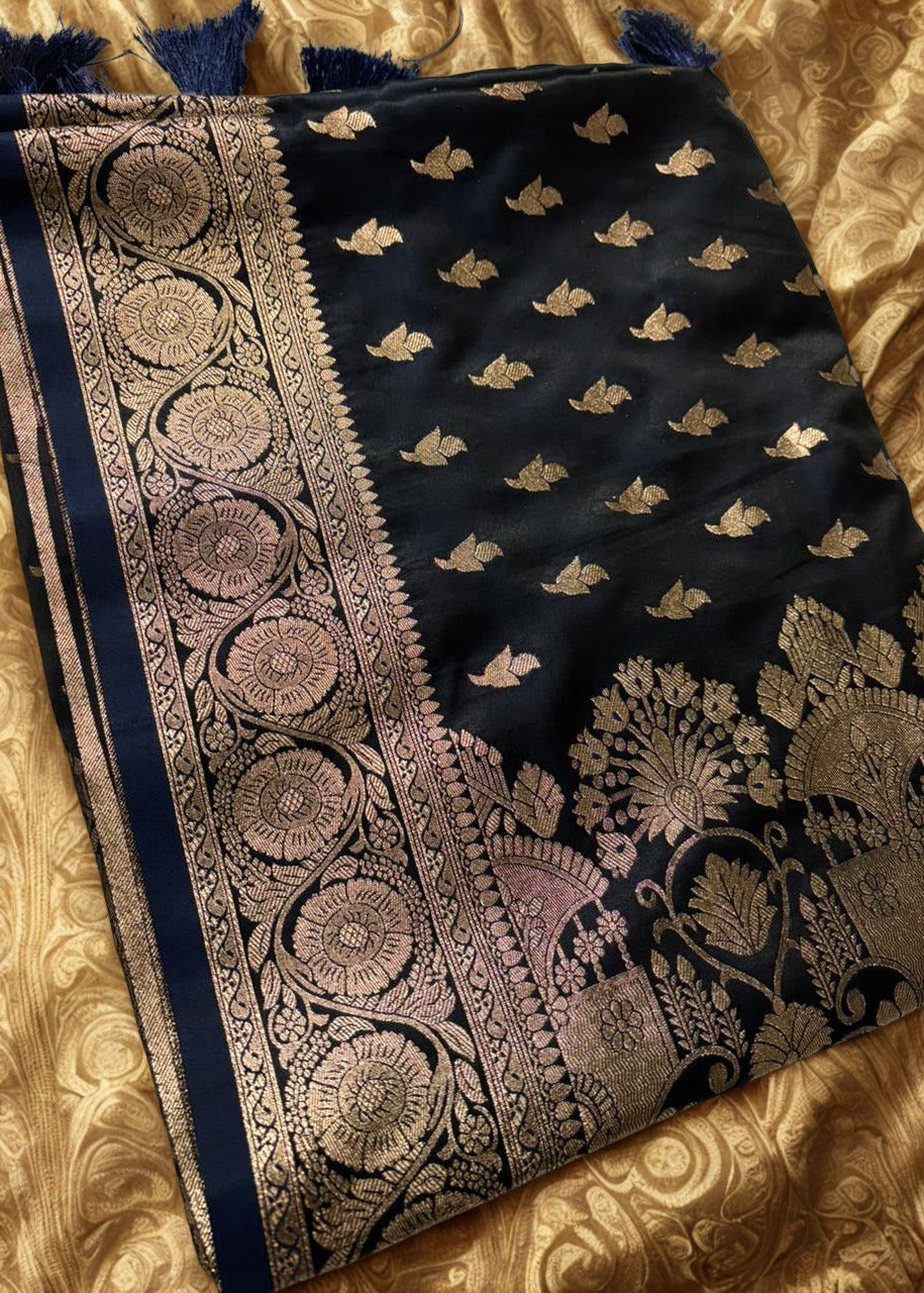 Folded Navy blue Banarasi Silk Saree with intricate zari work placed over a gold textured background
