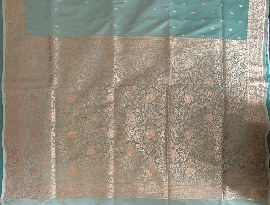 Close-up of large gold zari blooms and winding vines on aqua blue Banarasi pallu