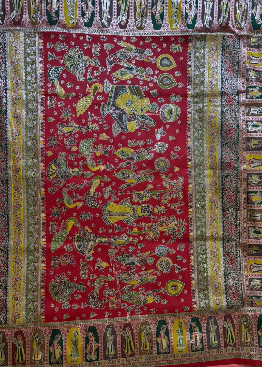 Colorful traditional fabric with intricate patterns and characters on a red background Pallu