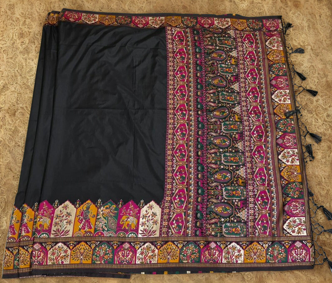 Black fabric with colorful embroidered border on a beige background