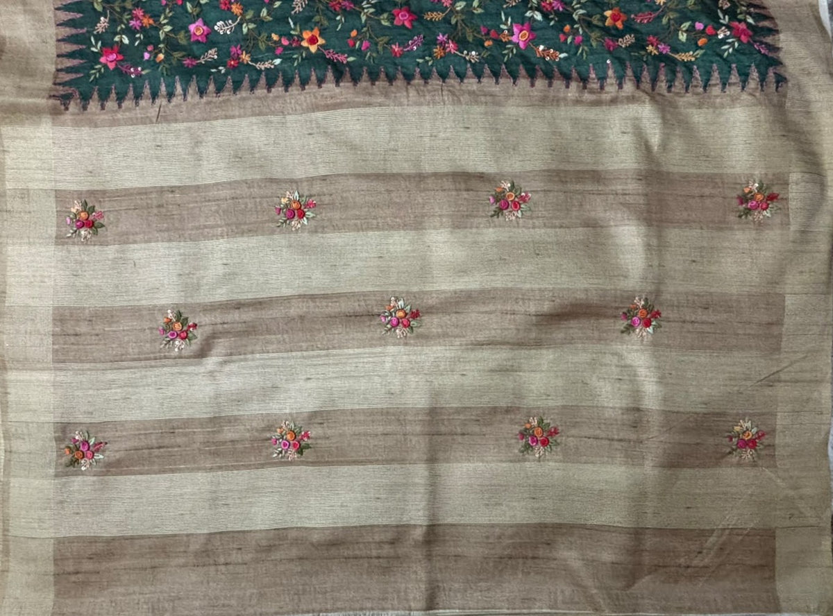 Close-up of hand-embroidered Kantha wildflowers in pink, orange and lavender on bottle green saree