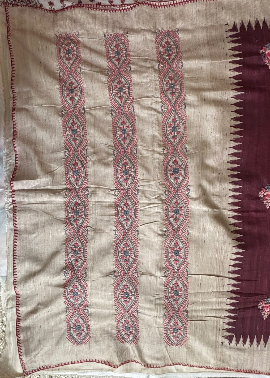 Pallu Design of Boolian Kantha saree with three vertical Embroidery panels of red and blue floral embroidery, finished with a deep maroon border featuring a pointed zigzag edge and small floral motifs.