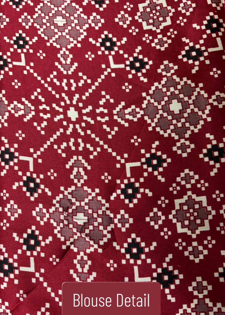 Close-up of a red Ajrakh blouse with intricate white and black pattern