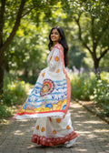 Woman wearing white handloom saree with Durga motif pallu, red border and traditional Bengali design, perfect for Pujo and festive occasions