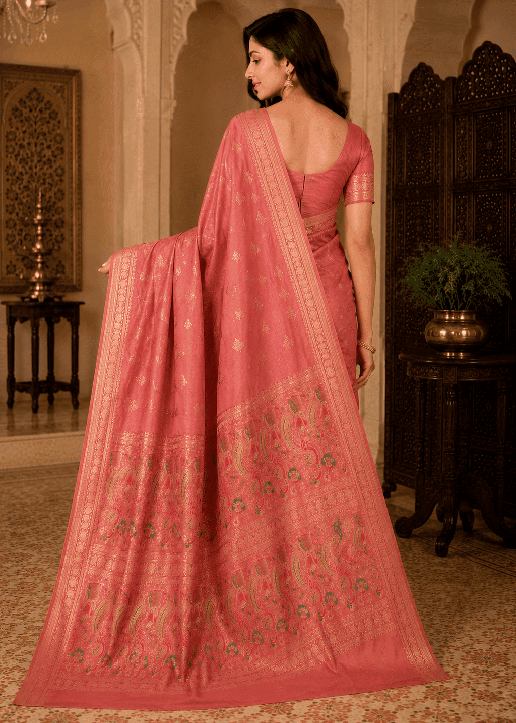 Full-length shot of a woman in a dusty rose peach Baluchari silk saree featuring subtle all-over motifs, a fine woven border, and an elaborate pallu depicting traditional paisley patterns and mythological artwork