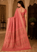Full-length shot of a woman in a dusty rose peach Baluchari silk saree featuring subtle all-over motifs, a fine woven border, and an elaborate pallu depicting traditional paisley patterns and mythological artwork