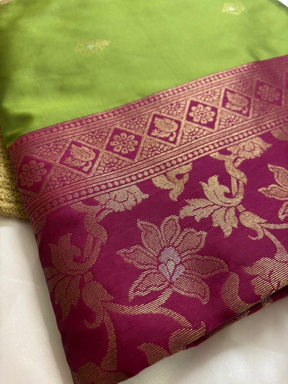 Magenta zari border with gold floral weave on a green silk saree