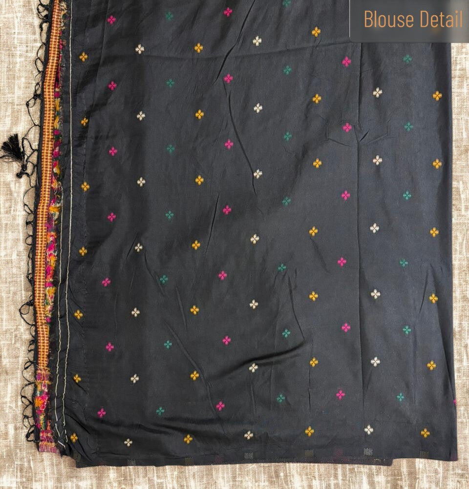 Black blouse with colorful floral patterns on a textured surface