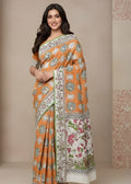 Woman wearing an orange and white Kalamkaree saree with intricate patterns against a beige background