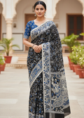 Woman wearing Neelambara indigo Kalamkari cotton saree with folk art prints and detailed blue border, elegant traditional Indian ethnic look