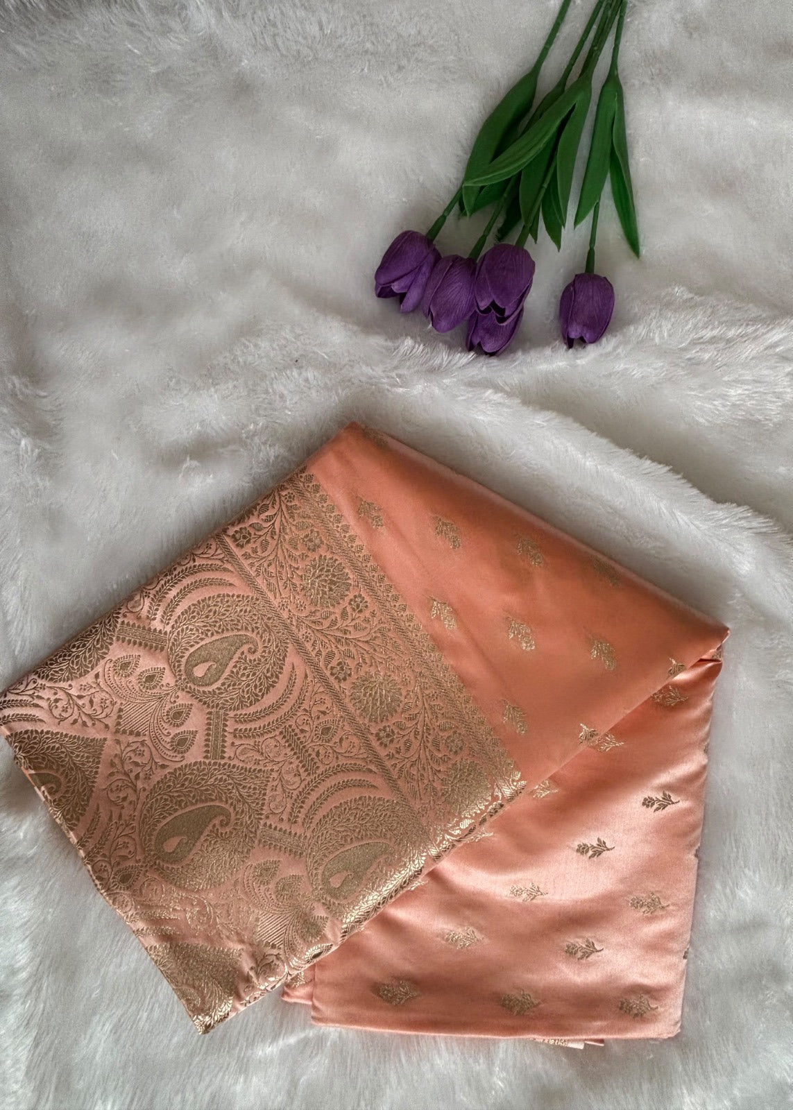 Delicate gold zari buttis woven on peach Banarasi silk saree body
