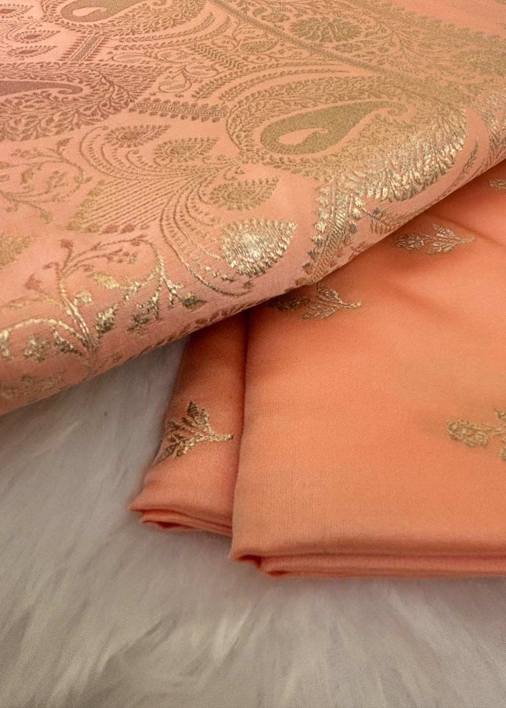 Delicate gold zari buttis woven on peach Banarasi silk saree body
