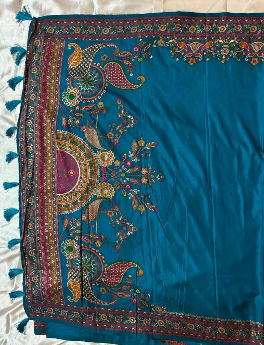 Mandala and paisley embroidery on the pallu of a teal blue saree with tassels