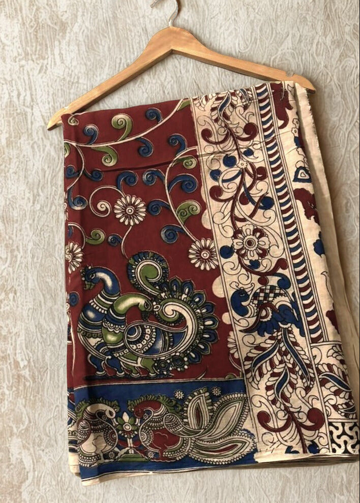 Kalamkari Saree on a wooden hanger against a light background
