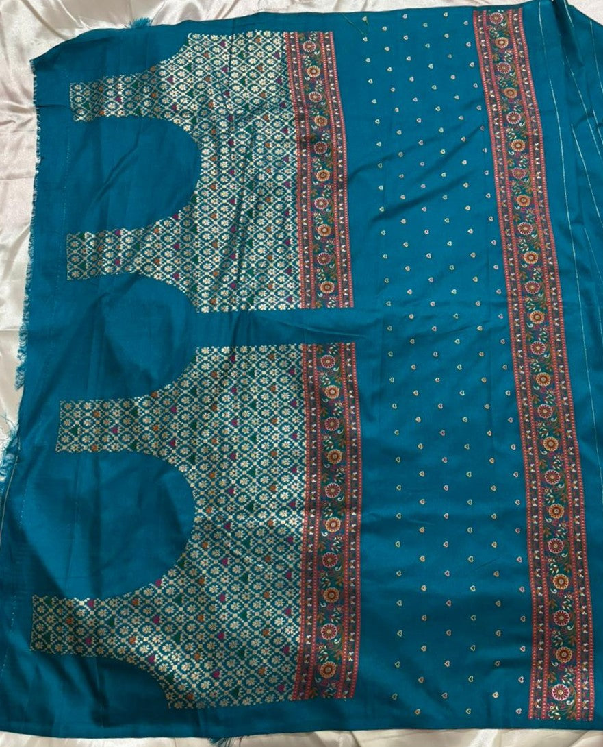 Matching blouse yokes of a peacock teal blue laid flat on a white fabric background.