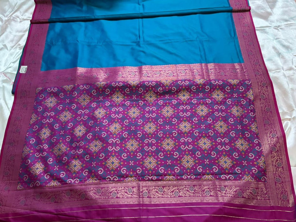 Purple and pink woven geometric pallu of a teal silk saree with Zari work