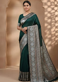 Woman wearing a green modal silk Azrakh saree with a patterned border against a beige background