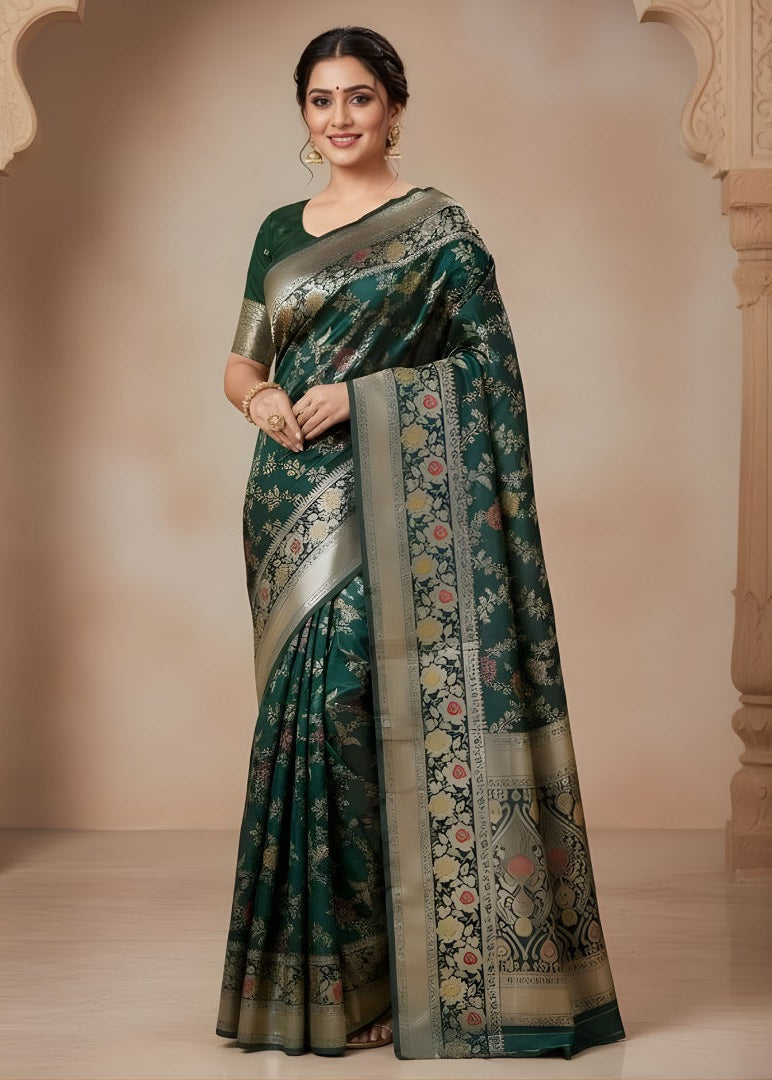 Woman wearing a green Banarasi saree with floral patterns in an indoor setting